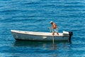 Elderly Man Rowing on his White Motorboat - Mediterranean Sea Italy Royalty Free Stock Photo