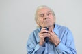 Elderly man shaving with a cordless electric razor Royalty Free Stock Photo