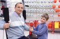 Elderly man in shop on sports exerciser and boy Royalty Free Stock Photo