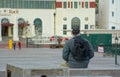 Elderly man sits alone outdoors.