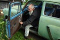 Elderly man sits in an old Soviet-made car, Moskvich 403.