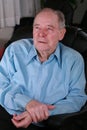 Elderly man sitting in chair , thinking