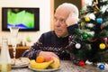 Elderly man sitting at a home table during the celebration of Christmas Royalty Free Stock Photo