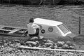 Elderly man sitting next to a boat in the river