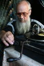 Elderly man sitting next to the old gramophone