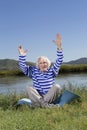 Elderly man sitting on a river bank Royalty Free Stock Photo