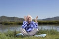 Elderly man sitting on a river bank Royalty Free Stock Photo