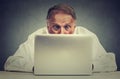 Elderly man sitting at table working on laptop computer Royalty Free Stock Photo