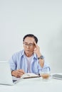 Elderly man sitting worried in front of his laptop in living room Royalty Free Stock Photo