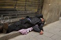 An elderly man sleeping on the doorstep of a building