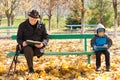 Elderly man and small boy sitting on a park bench