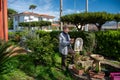 An elderly man spills feed into the goldfish tank in his garden