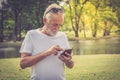 Elderly man standing  and using his mobile phone to text message Royalty Free Stock Photo