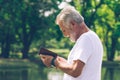 Elderly man standing  and using his mobile phone to text message Royalty Free Stock Photo