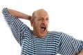 Elderly man in a stripped vest yawns Royalty Free Stock Photo