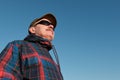 An elderly man in sunglasses and a baseball cap looks away. Royalty Free Stock Photo