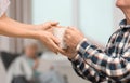 Elderly man taking cup of tea from female caregiver at home Royalty Free Stock Photo