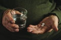 Elderly man taking his medication, two tablets. Royalty Free Stock Photo