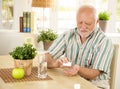 Elderly man taking pill at home