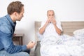 Elderly man taking a pill while sitting in bed Royalty Free Stock Photo