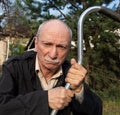 Elderly man threatening with a cane