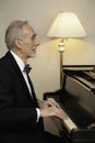 Elderly man in tuxedo playing piano Royalty Free Stock Photo