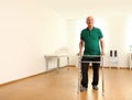 Elderly man using walking frame indoors. Royalty Free Stock Photo