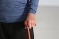 Elderly man with walking cane on blurred background, closeup of hand. Royalty Free Stock Photo