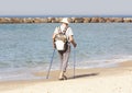 An elderly man walks with nordic walking sticks Royalty Free Stock Photo