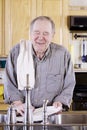 Elderly man washing dishes Royalty Free Stock Photo