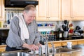 Elderly man washing dishes Royalty Free Stock Photo