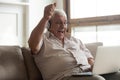Elderly man watching online sport match celebrating victory of team