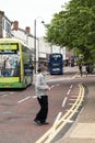 Elderly man wearing a mask walking across the road