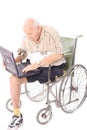 Elderly man in wheelchair on laptop vertical Royalty Free Stock Photo