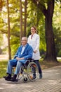 Elderly man on wheelchair with nurse outdoor Royalty Free Stock Photo