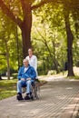 Elderly man on wheelchair with nurse outdoor Royalty Free Stock Photo