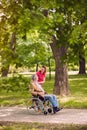 Elderly man in wheelchair talking with daughter in the park- hap Royalty Free Stock Photo