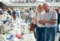 Elderly man and woman consider things in flea market Royalty Free Stock Photo