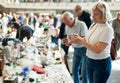 Elderly man and woman consider things in flea market Royalty Free Stock Photo