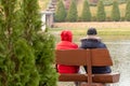 Elderly man and woman are sitting on a bench by the lake Royalty Free Stock Photo