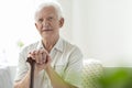 Elderly man with wooden walking stick in the nursing house