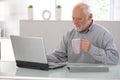 Elderly man working on laptop smiling Royalty Free Stock Photo