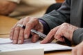 An elderly man writes a pen in the questionnaire. Old age and learning. Unemployment and retirement Royalty Free Stock Photo