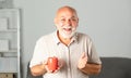 Elderly managing director with cup of tea. Mature caucasian man at home. Portrait of happy smiling senior businessman in Royalty Free Stock Photo