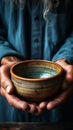 Elderly mans hands clutch empty bowl on wooden surface, representing hunger and poverty