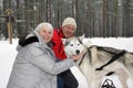 Man and woman cuddling up with Siberian Husky