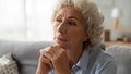 Elderly mature grey haired woman lost in thoughts