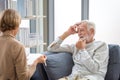 Elderly man consulting senior woman on the cozy sofa at home, Elderly medical health care concepts, Senior couple in living room Royalty Free Stock Photo