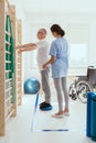 Man doing gymnastic exercises with a young female physiotherapist