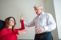 An elderly man hypnotizes a female patient. A woman in a session with a male hypnotherapist during a session. Therapist Royalty Free Stock Photo